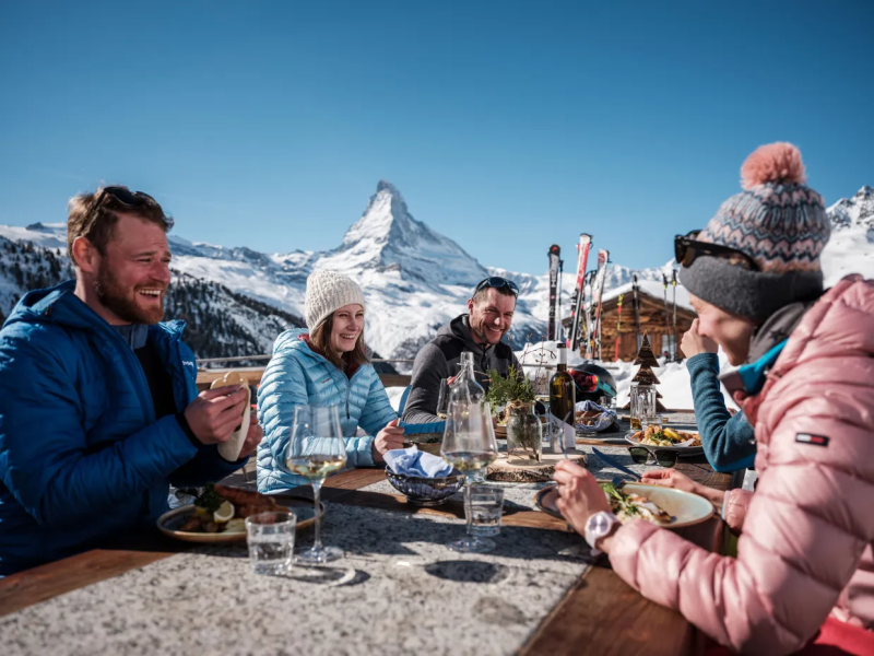 Gasten genieten van après-ski op het terras in Zermatt