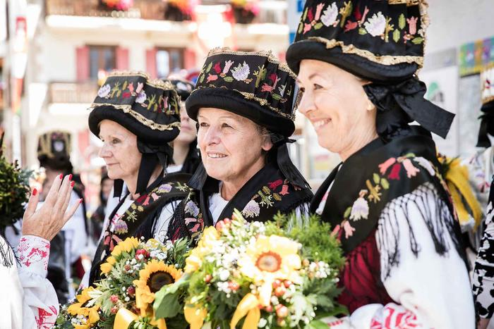 Vrouwen in klederdracht met bloemen tijdens het folklorefestival in Zermatt